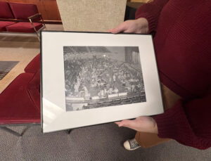 Someone holding a framed image of the inside of an auditorium