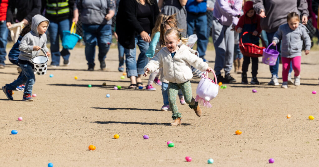 Children pick up Easter eggs at a ball park