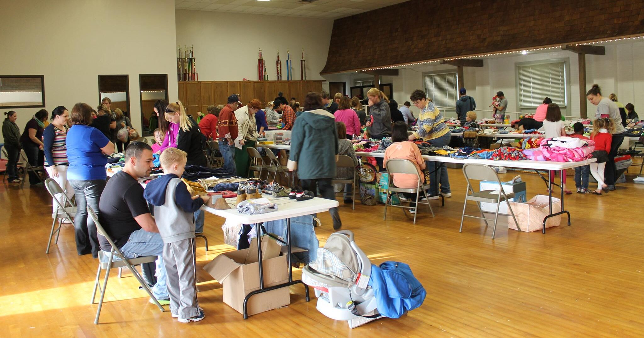 People at booths at an indoor garage sale