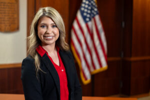 Portrait of Kaylyn Hite in courtroom with U.S. flag in the background