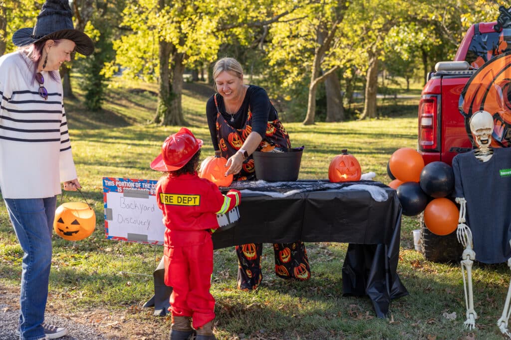 A child dressed as a firefighter picks out candy during a trunk-or-treat event in Pittsburg, KS